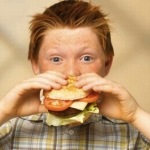 Мальчик ест бутерброд